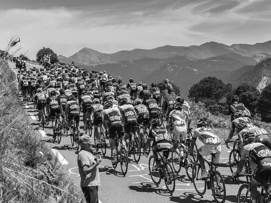 Pro cycling peloton crossing a mountain pass, monochrome